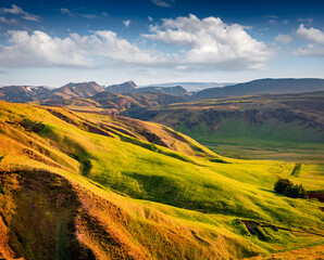 Typical Icelandic rolling hills landscape with glacier on background. Bright summer morning on the...