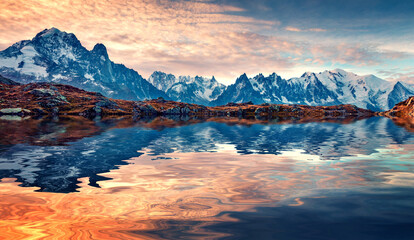 Snowy Mount Blank peak reflected in the calm waters of Cheserys lake. Autumn sunset in French Alps,...