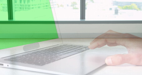 Image of hands using laptop with green screen over sped up commuters walking in modern building