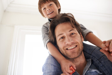 Father with son on his shoulders, portrait and home with smile and love with single parent and bonding together. Family, dad carrying boy and childhood with fun and playing with joy and happiness