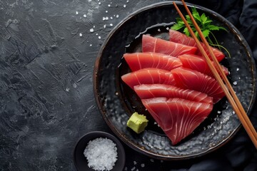 Sashimi set with tuna and shrimp trespass and a cup of soy sauce on a dark background
