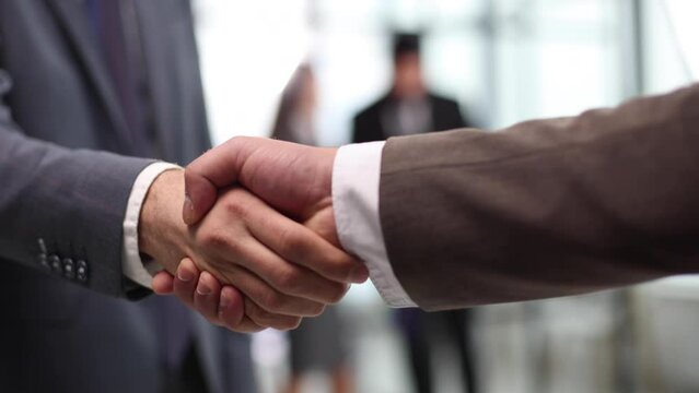 closeup.reliable handshake of business partners with colleagues in the background