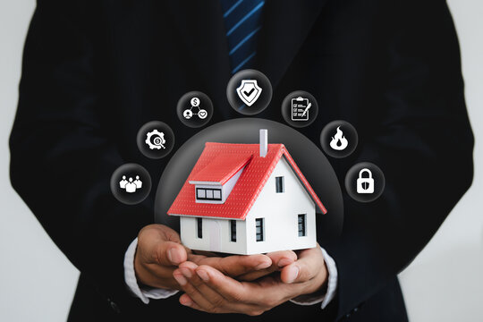 Man insurance agent holding house model with home insurance icon. Property insurance security concept to protect family, real estate from accidents and unexpected disaster.