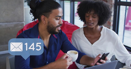 Image of social media icons of over diverse man and woman in restaurant