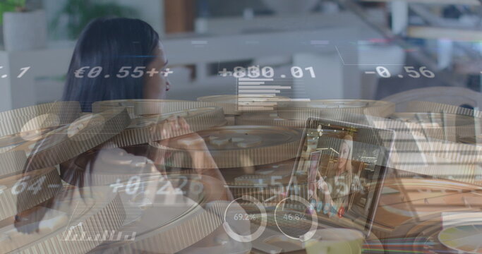 Young biracial woman analyzing financial data overlaying the image