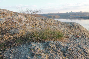 
Rock against the background of the river. Close-up of a rock.