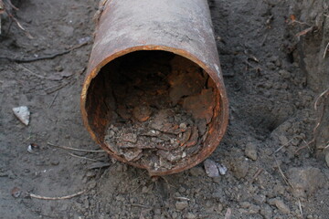 
A rusty pipe comes out of the ground.