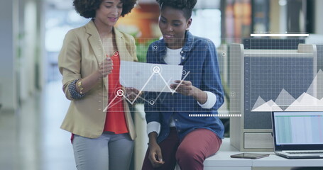 Image of financial data processing over diverse businesswomen in office