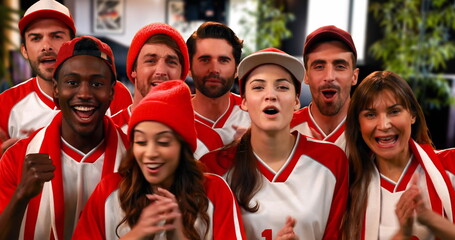 Front view of sports fans wearing white and red jerseys cheering for their team