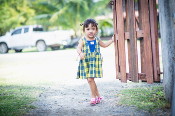 A girl opens the door to a flower garden and welcomes herself into beautiful nature.