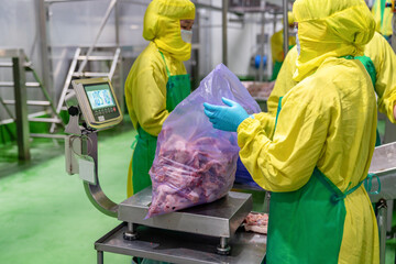 The workers weigh chicken parts.