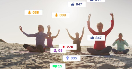 Image of social media notifications, over women doing yoga sitting on beach