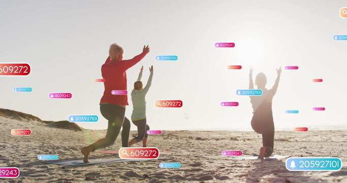 Image of social media notifications, over women doing yoga on beach - Powered by Adobe
