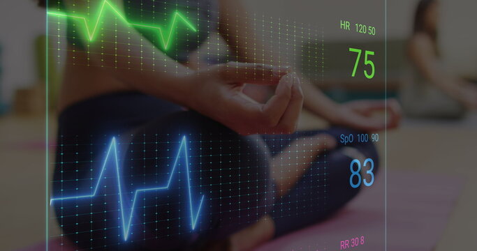Image of neon heart rate over midsection of caucasian woman practicing yoga