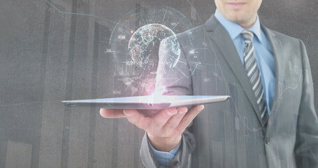 Image of financial data processing and globe with connections over businessman holding tablet