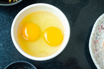 Two eggs in a small bowl. Egg Yolk contain protein, vitamins, minerals, omega 3 and other nutrients
