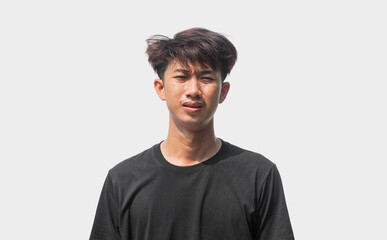 A young Asian man in his 20s wearing black t-shirt is depressed and worried in distress standing on...