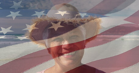 Image of happy senior african american woman at beach over american flag