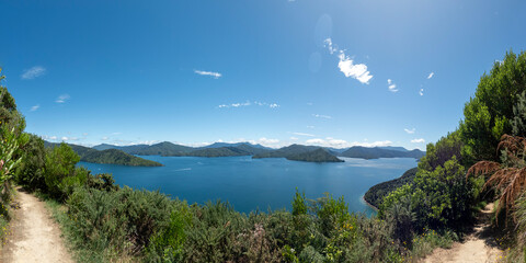 The Marlborough Sounds : Panoramoc view on coastal landscape with lush green hillsides andsecluded bays, with blue water and clear sky, New Zealand