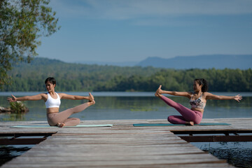Beautiful attractive Asian woman practice fitness yoga pose on the pool above the Mountain peak in front of nature lake views, Feel so comfortable lifestyle and relax exercise in holiday morning