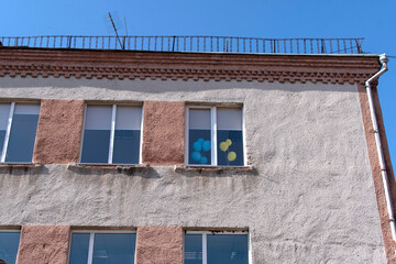 Blue and yellows air ballons in a window of a building