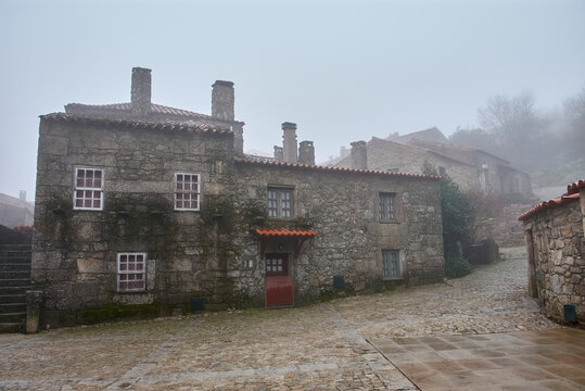 Narrow streets among the fog of the historic village of Sortelha in Portugal