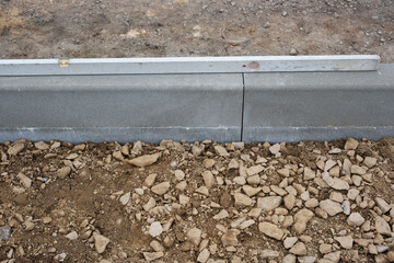 Strassenbau, Einbau von Randsteinen aus Beton