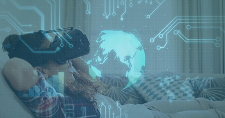 Image of globe spinning and processor elements over smiling boy wearing vr headset