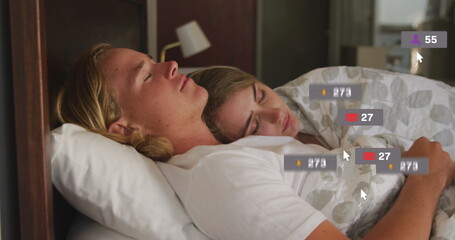 Image of social media notifications over happy couple asleep in bed embracing