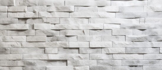 Close up of a monochrome white brick wall with a geometric pattern made of grey and beige rectangles, showcasing the symmetry of brickwork building material