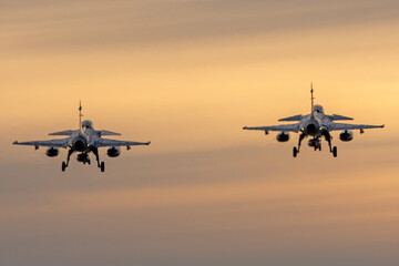 Fototapeta na wymiar Aviones de combate aterrizando al anochecer