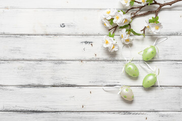 Easter eggs and decorative blossoming cherry branch on a white wooden background. Top view, flat lay. - 757043541