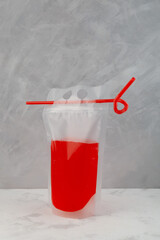 Adult drink in reusable pouch with drinking straw. Alcohol cocktail in plastic bag very convenient...