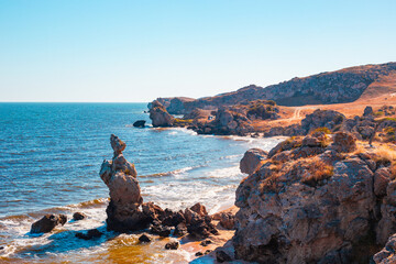 Seascape. Bizarre rocks on the seashore on a sunny summer day. General beaches of the Azov Sea