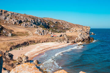 Seascape. Rocky sea coast with a small wave on a sunny summer day. General beaches of the Azov Sea