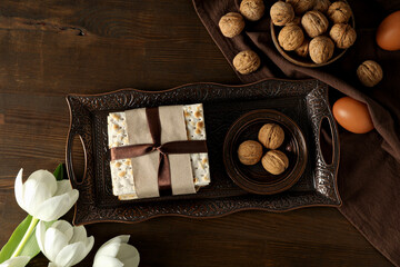 Matzo, nuts, eggs and flower on tray on wooden background, top view