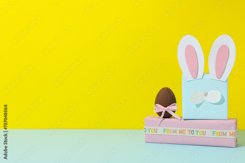 Poster Blue gift box with rabbit ears on a yellow background