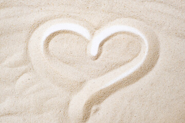 Painted heart on the sand top view.