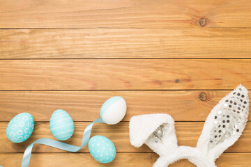 Blue easter eggs with bunny on wooden background, top view