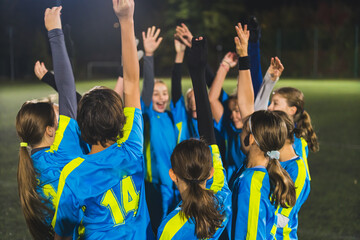 young football player girls standing in a circle holding hands up and preparing for the game, teamworking. High quality photo © PoppyPix