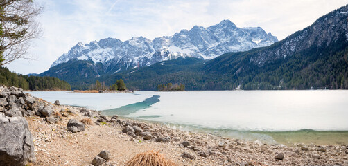 frozen lake Eibsee with small channel. view to Zugspitze mountain mass. bavarian landscape