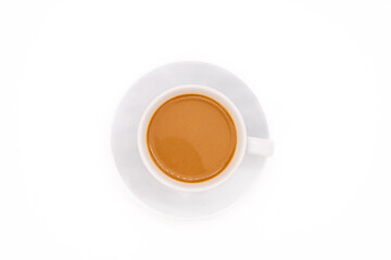 Creamy coffee on a white porcelain cup, isolated on white background with copy space. Top view or flat lay.