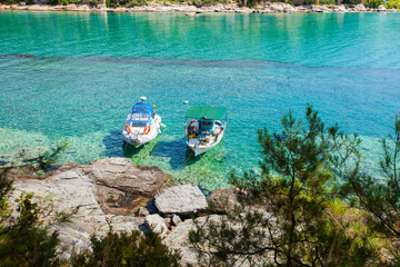 Two boats on crystal clear waters, serene and picturesque scene.