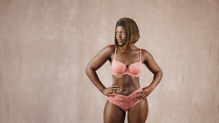 A confident young woman feels positive and comfortable in her body. Body Positive and vitality concept in a studio.