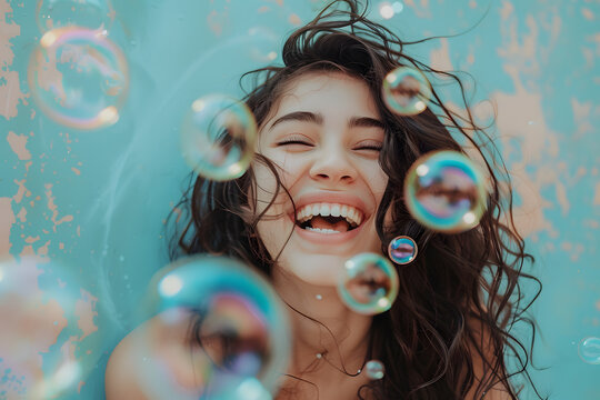 Closeup portrait of happy smiling young woman with  soap bubbles