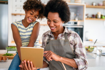 Portrait of happy mother with child using digital tablet for education, fun, game. Technology people