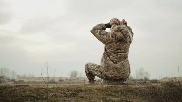 In the midst of conflict, a female military service member takes a moment to tie her hair, against the serene backdrop of a beautiful sunset, maintaining poise even in wartime. Camera 8K RAW.