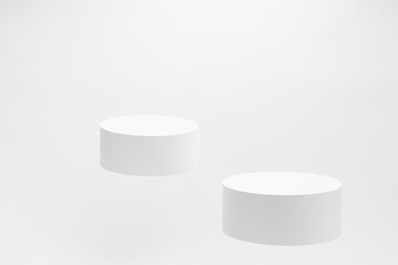 Set of two round white pedestals mockup for cosmetic products, fly  on white background. Scene for presentation skin care products, gifts, advertising, sale, design, showing, text in elegant style.