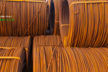 An open-air warehouse with twisted spools of rusty wire.