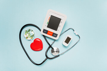 stethoscope, heart model, pills, and digital devices on Pale Blue Background symbolizing love and care in the medical field.